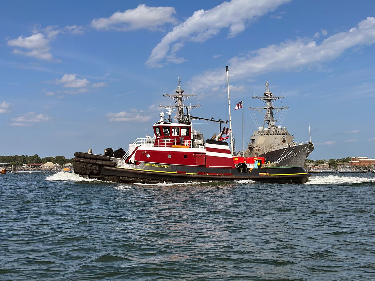 The tugboat Jane McAllister sails past a US Navy vessel in Virginia.