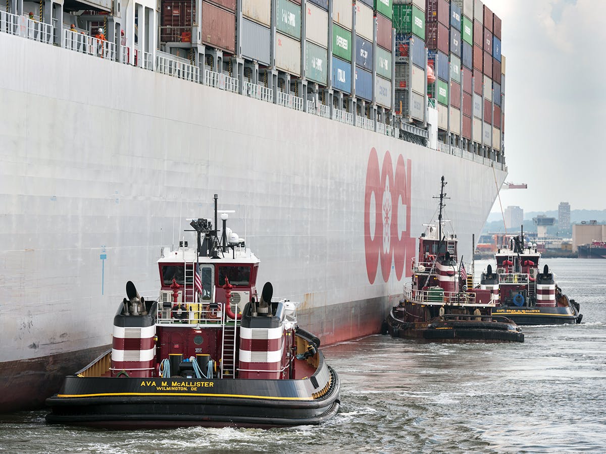 Three McAllister tugboats along the starboard side of an OOCL containership, guide the gentle giant safely to the dock in Port Newark.