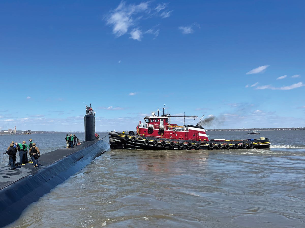 The Robert McAllister safely eases on to the USS Delaware, a Virginia class attack submarine.
