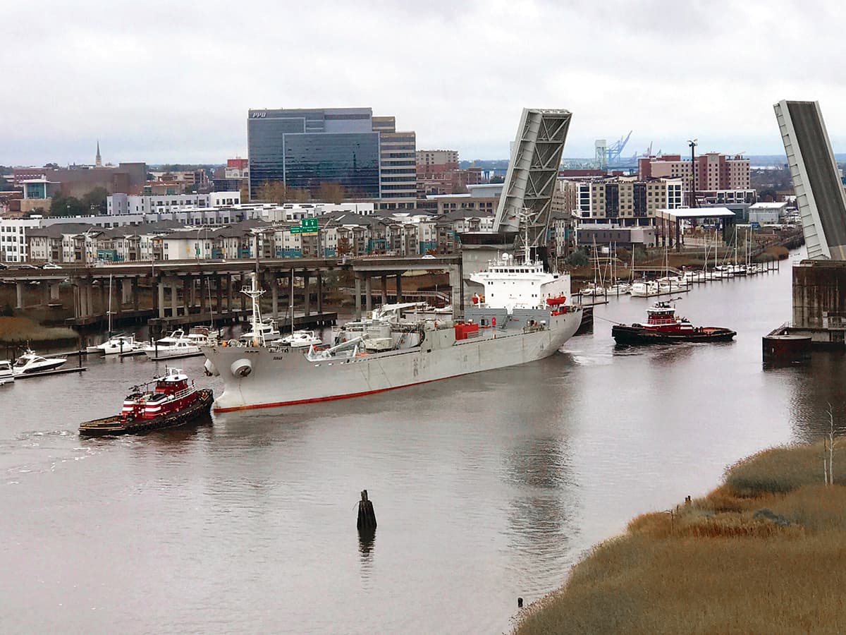 The tugs Erin and Margaret McAllister assist a cement carrier through the Isabel Holmes bridge in Wilmington, North Carolina.
